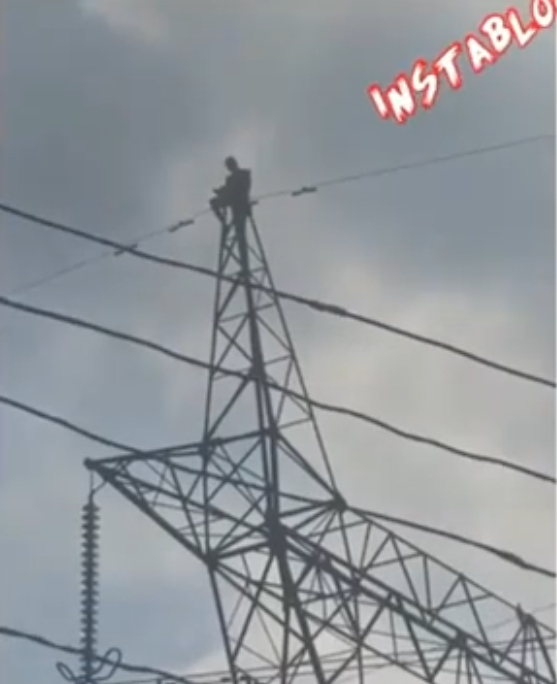 Pastor climbs high tension pole